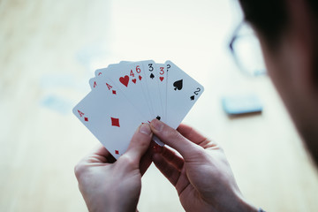 Playing cards: Poker cards in the hand of a young man
