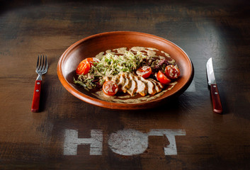 Chicken breast salad laid out on a clay plate.