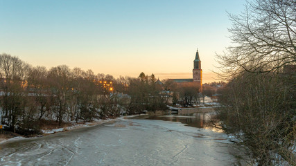 Sunset view to the icy Aurajoki river in Turku, Finland. February 2019.