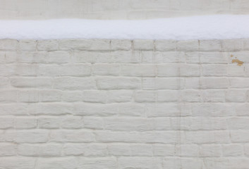Snow on a white brick wall as background.