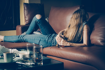 Young drunk woman on the sofa. Young drunk woman on the sofa. Alcoholism and drug addiction lead to depression. - obrazy, fototapety, plakaty