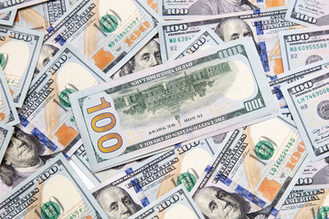 One hundred dollar bills on the table as background