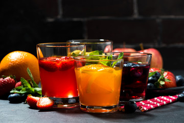 fresh fruit lemonades in assortment on dark table