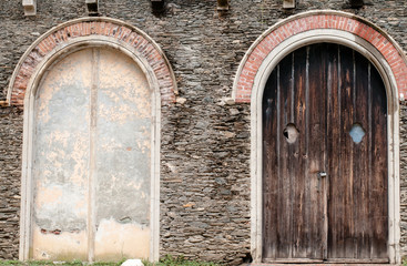 Fototapeta na wymiar old wooden and concrete doors in brick wall