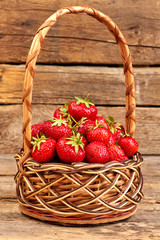 Fototapeta na wymiar Basket with fresh strawberries. Healthy ripe strawberries in basket on old wooden background. Fruits for gourmet.