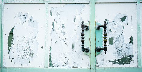 metal handles on an old scratched wooden door 