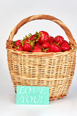 Fototapeta na wymiar Juicy organic strawberries in basket. Wicker basket with ripe strawberries on white background. Romantic fruity composition.