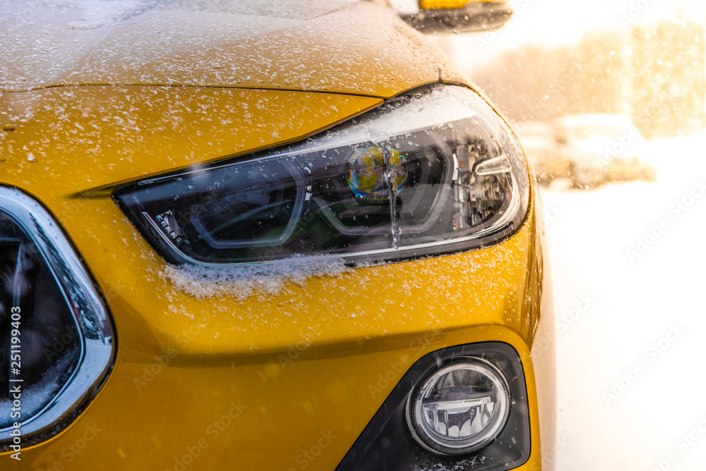 Wall mural The image in front of the yellow SUV car scene behind as the sun going up with snowflakes in the right