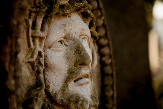 Ancient statue of the crucifixion of Jesus Christ in profile. Religion, faith, death, suffering, immortality, God concept.
