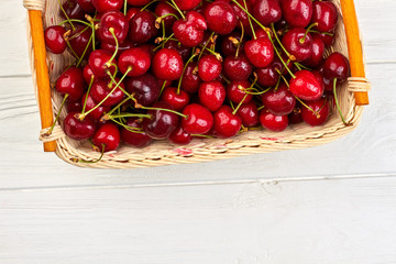 Freshly harvested cherries in basket. Ripe sweeet berries in wicker basket and copy space. Healthy eating concept.