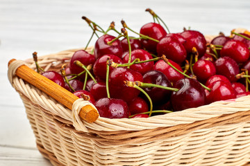 Sweet red cherries in wicker basket. Fresh natural berries close up. Healthy food and diet.