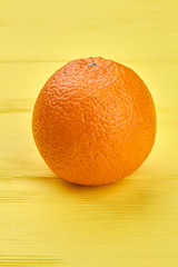 Big healthy orange fruit. Fresh organic orange on yellow wooden background with copy space. Citrus for healthy eating.