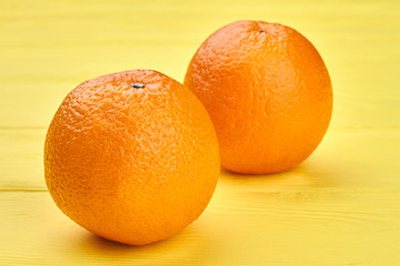 Two whole delicious oranges. Fresh tasty oranges on color background. Healthy eating concept.