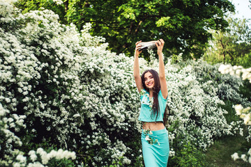 young girl enjoying spring blooming nature. girl sprinkles herself with flower petals.