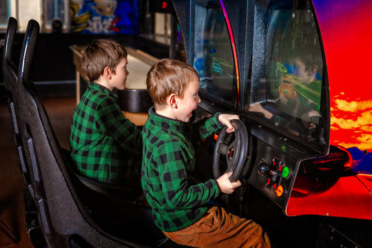 children at the arcade machine. excited kids playing car race 