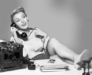Young blonde female writer using typing machine, black and white portrait