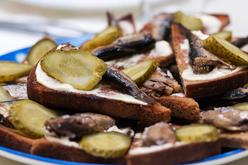 Sandwiches with sprats. Bread, mayonnaise, fish, pickles.