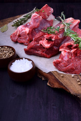 Raw beef ribs, rosemary, thyme and spices on a wooden board