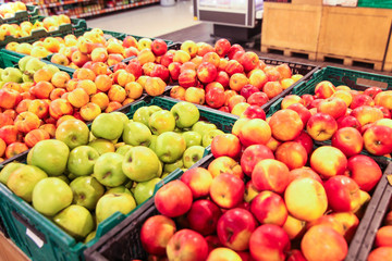 Large selection of red green and yellow apples in baskets in supremacret
