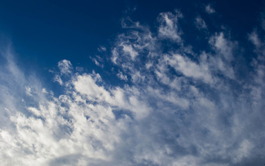 Naklejka na ściany i meble feathery tips of gray nimbus clounds moving across a blue sky