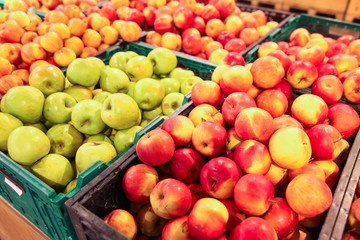 Large selection of red green and yellow apples in baskets in supremacret