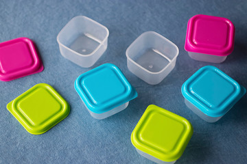 Square plastic containers with bright multi-colored lids.