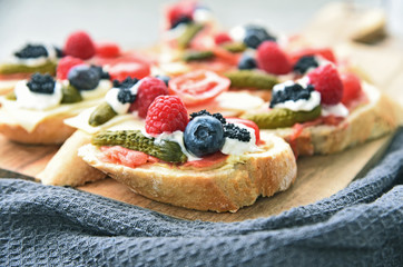 A lot of open-faced sandwich with berries  on wooden broad (German name is Belegtes Brot)