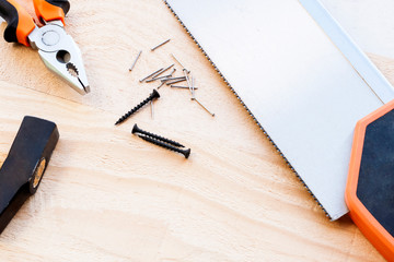 Hammer, nails and pliers lie on a wooden background. Construction Tools Selective Focus.