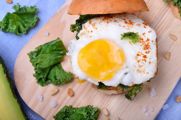 Sandwich with fried egg and salad with kale