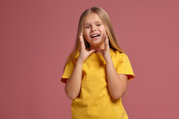 little girl in a yellow t-shirt. looking shyly