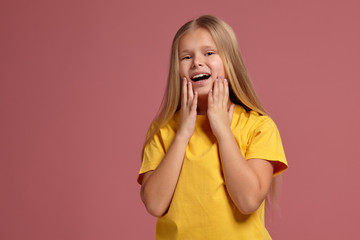 little girl in a yellow t-shirt. looking shyly