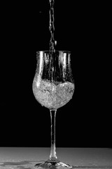 Close up view of splushing water in glass isolated. Black and white. Beautiful backgrounds.