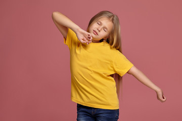 little girl in a yellow t-shirt. stretches and yawns
