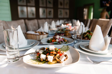 Enjoy a delicious greek mediterranean meal with salad vergetables very healthy and herbal at your tavern table behind crystal clear blue water and white sandy beach, Dodecanese Islands, Greece