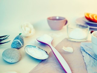 Obraz na płótnie Canvas Sea salt, sliced ​​orange, sea stones and shells, water on a bright table, ingredients for a mask, scrub, gentle care procedures