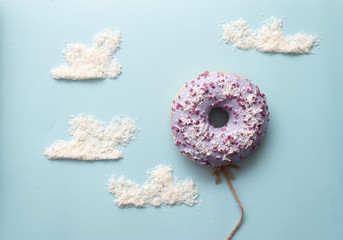 Concept purple donuts on a blue background with clouds minimalism