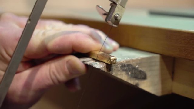 Jeweler makes a piece of jewelry - golden wedding ring