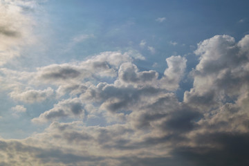 Scattered Cumulus clouds in the evening blue sky. Rain clouds are coming and foretell a change of...