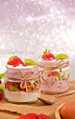 Mixed fruits and walnuts yogurt in glass with bow tie on Bokeh background..Breakfast with many kind of fruits and yogurt.