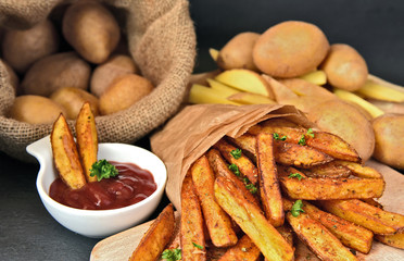 Homemade Crispy Seasoned French Fries..French fries  with spicy seasoning in brown paper bag on wooden broad.