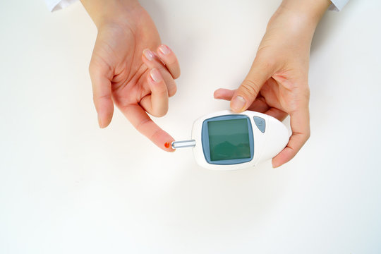 Photo of woman's hand with glucometer.