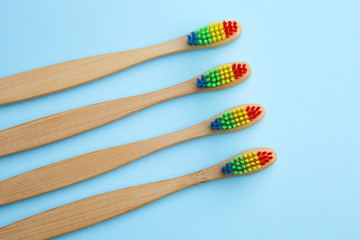Picture of four toothbrushes with rainbow-colored bristles.