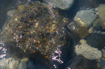 pebble stones on the sea beach, the rolling waves of the sea with foam