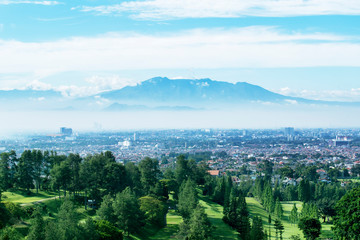 Fototapeta premium Pole golfowe z mglistym tłem miasta Bandung
