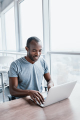 Young businessman working on his laptop in spacious bright office.