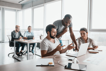 Three business colleagues discussing projects in modern office interior