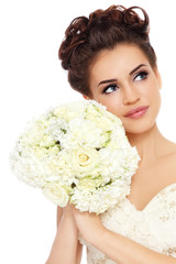 Young beautiful happy bride with winged eye make-up and prom hairdo holding fancy bouquet in her...