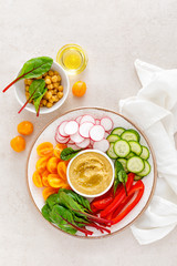 Vegetarian Buddha bowl with hummus and vegetables, top view
