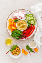 Vegetarian Buddha bowl with hummus and vegetables, top view