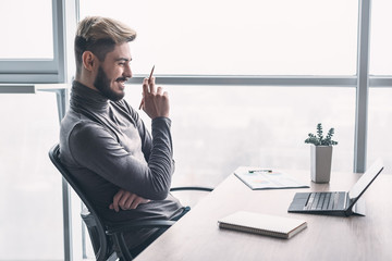 Stylish man working at computer in modern office. Side view
